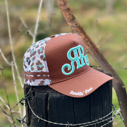 Brown cap with patterned side and 'Rambin' Rose' branding on a wooden post with barbed wire.
